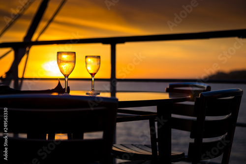 Wine glasses on balcony overlooking at sunset © Sergey Kelin