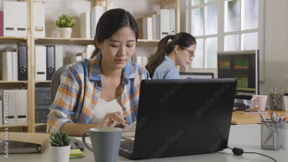 Female business analyst counting corporate profit company income analysis using calculator sitting at workplace desk. Office daily routine work in process. woman colleague concentrated working on pc Female business analyst counting corporate profit company income analysis using calculator sitting at workplace desk. Office daily routine work in process. woman colleague concentrated working on pc