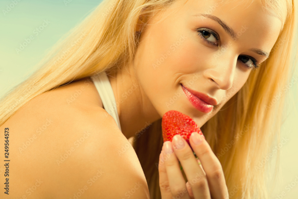 Young beautiful happy smiling woman with strawberry on sea beach Young beautiful happy smiling woman with strawberry on sea beach