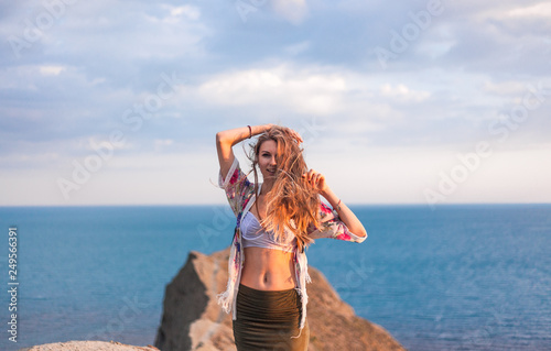Blonde with loose hair in the wind against the sea