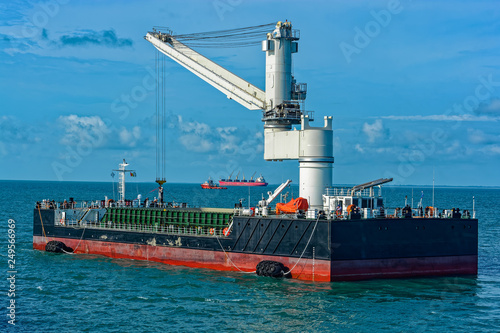 Floating Crane Transhipper with grab feeding system to cater to bauxite ore transhipment operations from barges at outer anchorage of Kamsar, Guinea. photo