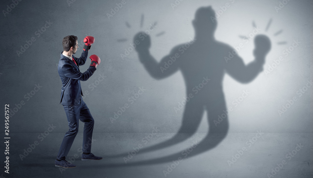 Businessman trying to fight with his unarmed shadow
Businessman trying to fight with his unarmed shadow