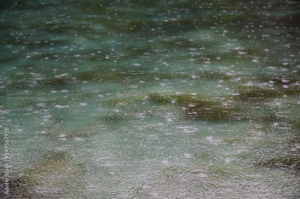 raindrops on the water surface of a deep blue lake