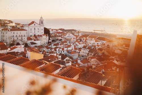 Sunrise Over Lisbon Old Town Alfama - Portugal. Lisbon Golden Hour Skyline. Balcony View on Alfama Old Town of Lisbon and Tagus River