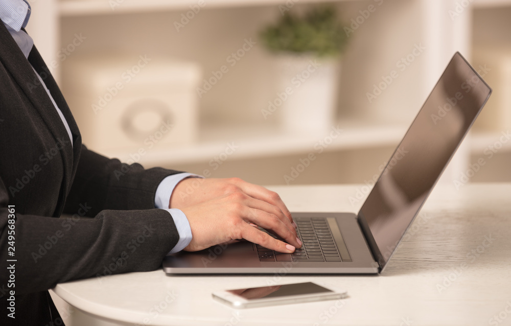Business woman below chest working on her laptop in a cozy environment
Business woman below chest working on her laptop in a cozy environment