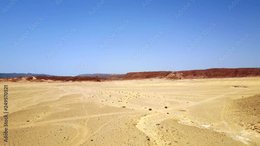 Aerial view of the sand dunes and mountain. Desert at sunset - mountain landscape with dust. Aerial view of the sand dunes and mountain. Desert at sunset - mountain landscape with dust.