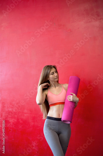 Fit woman is holding a yoga mat in a gym © Анна Волгина