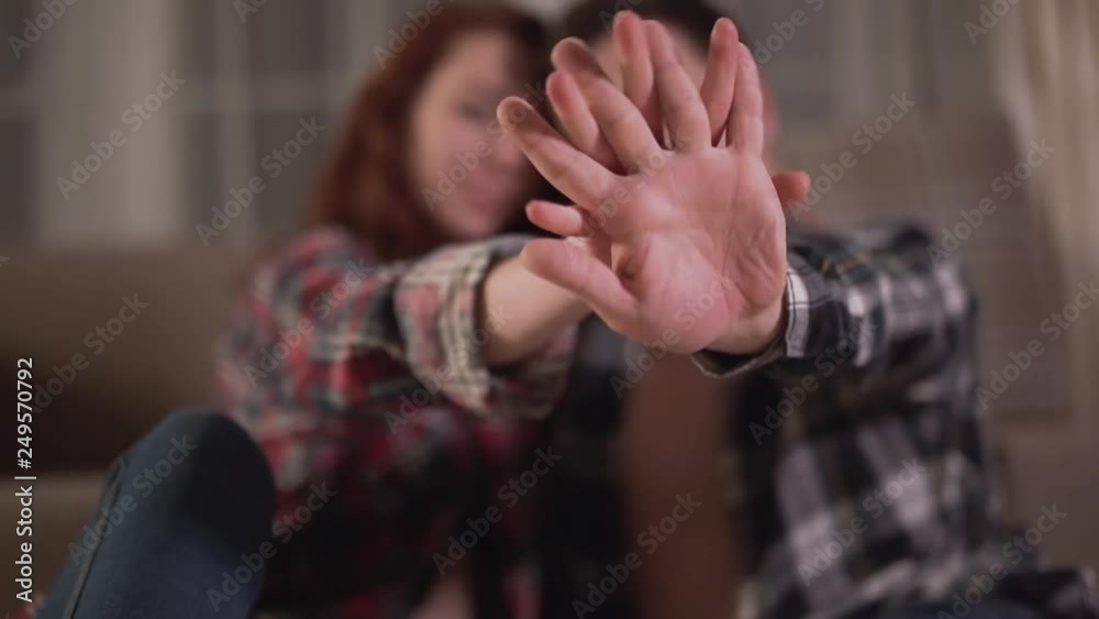 Silhouette of man and woman siting on the floor and strongly holding each others hands on a blurred background. Leisure of young family. Tender relationship of a young couple. Silhouette of man and woman siting on the floor and strongly holding each others hands on a blurred background. Leisure of young family. Tender relationship of a young couple.
