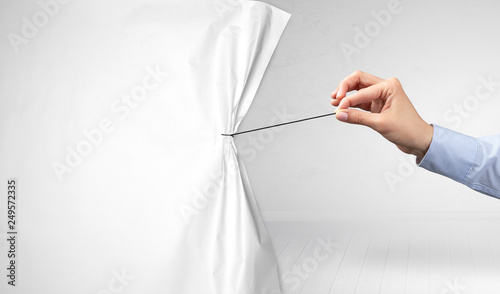 hand pulling white paper curtain, changing scene concept photo