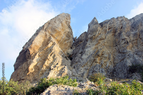 beautiful big high relief rocky stone cliff of sandy color on blue sky background in crimea