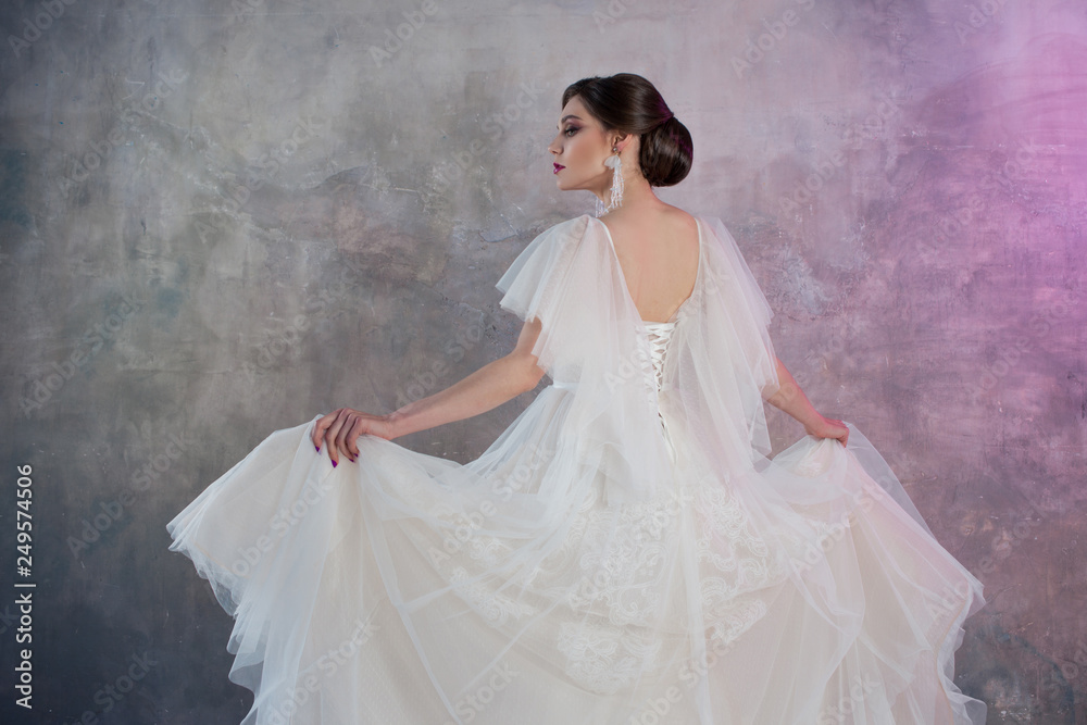 Beautiful and stylish bride in wedding dress with a lush flying skirt in