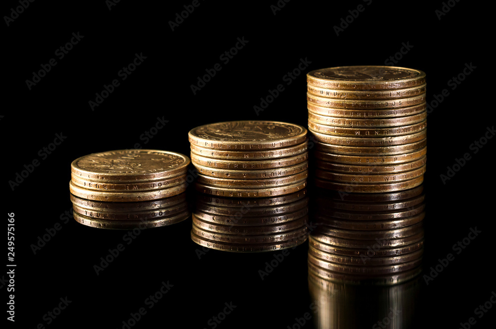 Stacks of gold coins on black reflective background. Business grows concept.