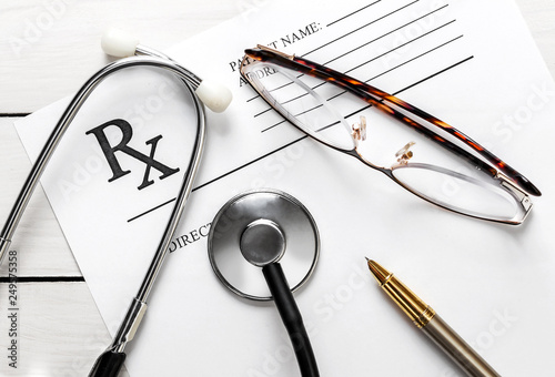 Konstfotografi Stethoscope with glasses, pen and prescription form on the white wooden table