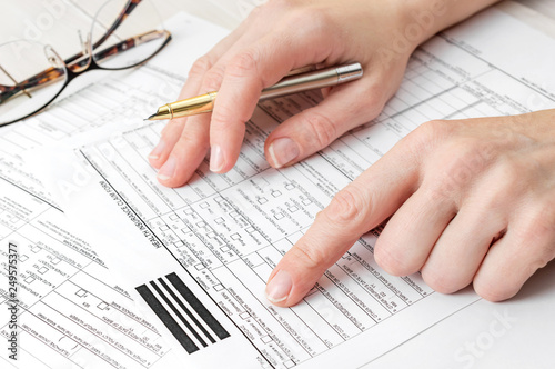Woman filling health insurance claim form. Close up. © igorkol_ter