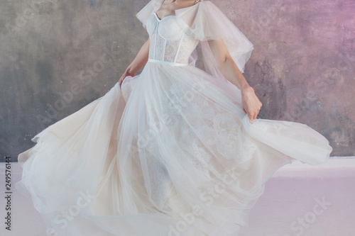 Beautiful and stylish bride in wedding dress with a lush flying skirt in