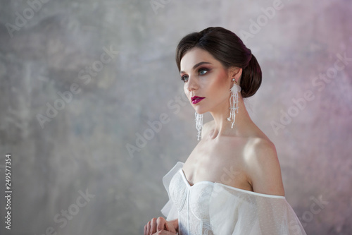 Beautiful and stylish bride in wedding dress in Studio on grey