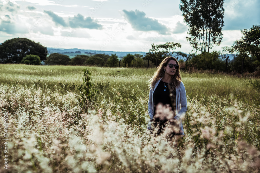 young woman having fun at sunset on a green grassy field young woman having fun at sunset on a green grassy field
