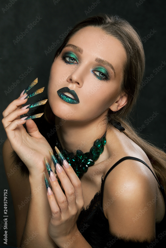 Fashion beautiful blonde woman with green nails and bright makeup.