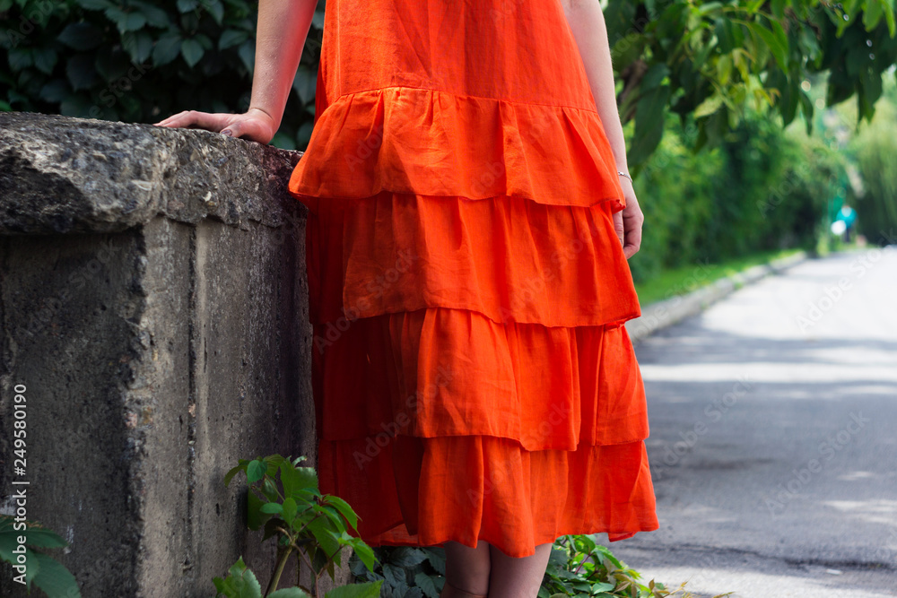 Beautiful woman in orange linen dress with ruffles, summer style, fashion