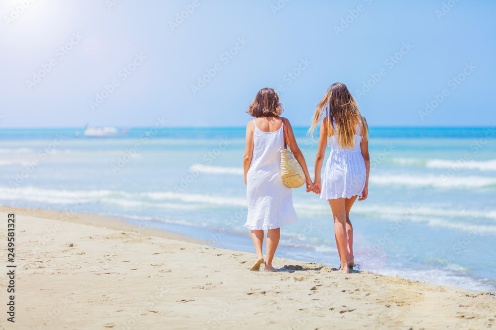Back view of Cute girl and her mother have a good time at the seaside resort