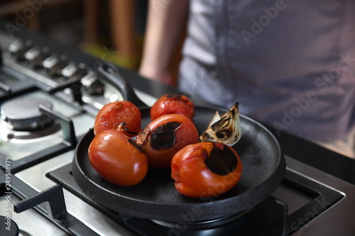 Charred tomatoes and garlic on a griddle