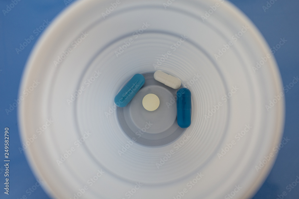 Drugs in tablets in plastic glass seen from above Drugs in tablets in plastic glass seen from above
