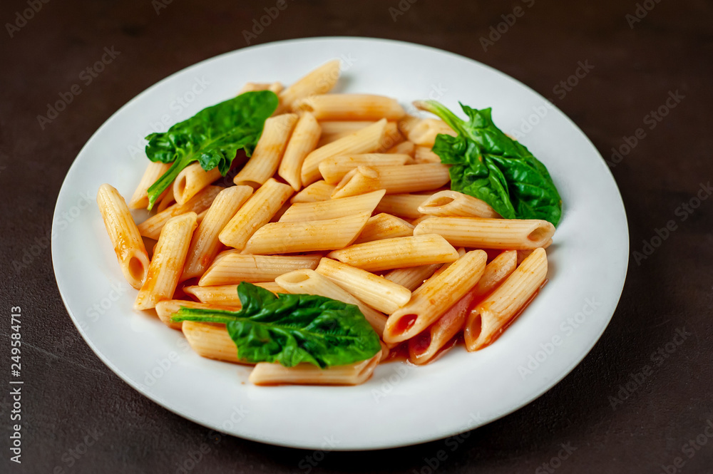 Penne pasta in tomato sauce on concrete background