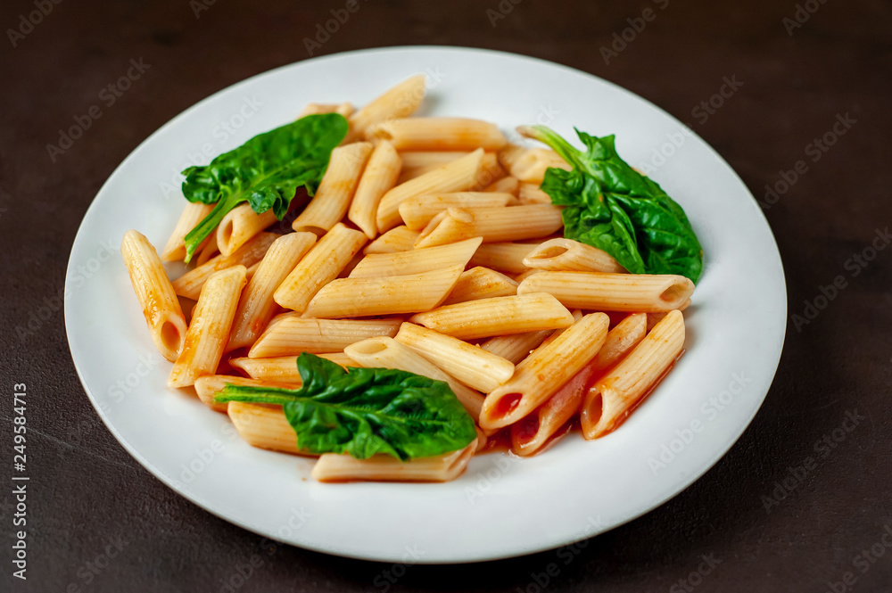 Penne pasta in tomato sauce on concrete background Penne pasta in tomato sauce on concrete background