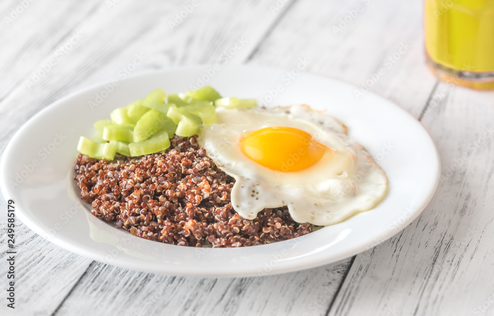 Portion of red quinoa with fried egg and celery Portion of red quinoa with fried egg and celery