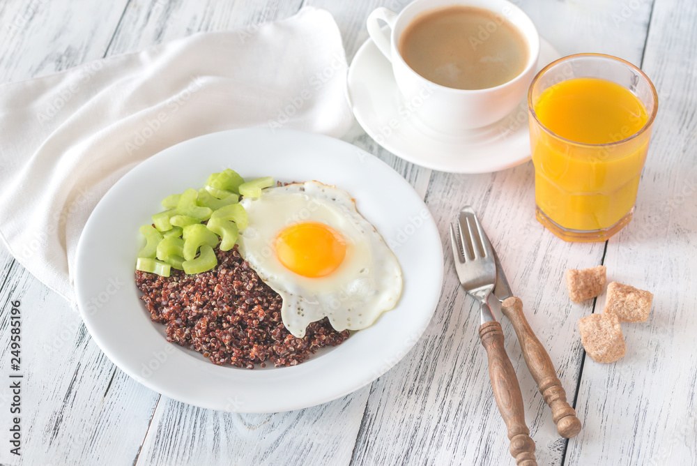 Portion of red quinoa with fried egg and celery Portion of red quinoa with fried egg and celery