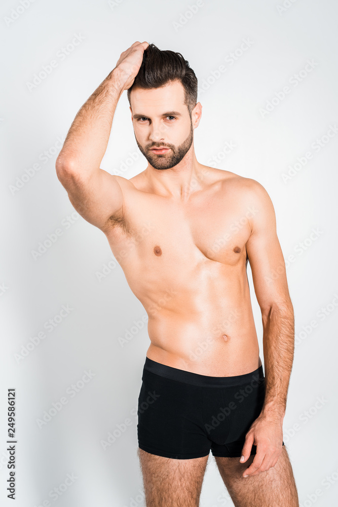 sexy bearded man posing in black underwear isolated on grey
