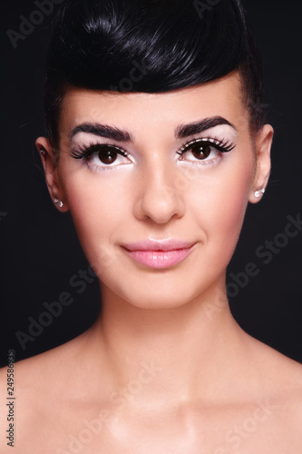 Portrait of young beautiful tanned girl with fancy make-up and hairstyle