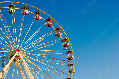 Close up ferris wheel with a blue sky background