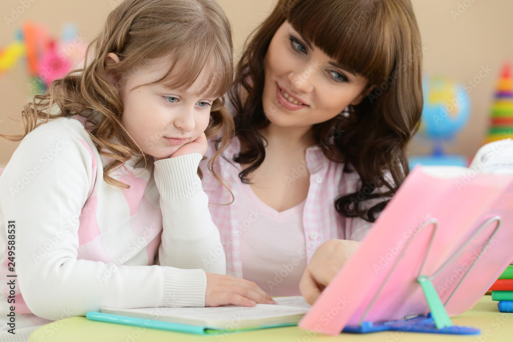 Portrait of mother with daughter doing homework Portrait of mother with daughter doing homework