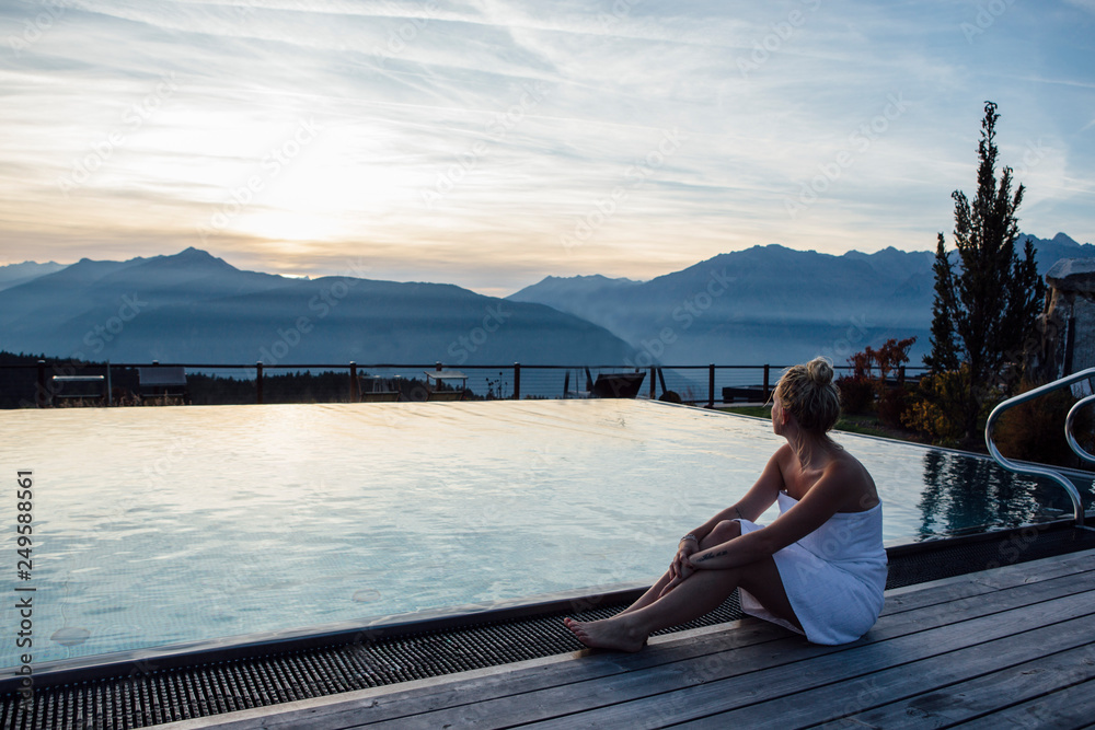 Woman relaxing at the poolside, wrapped in towel Woman relaxing at the poolside, wrapped in towel