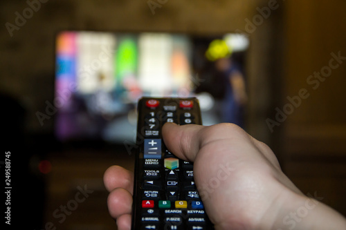 Hand hold the remote control to change channels on Tv. Hand hold the remote control to change channels on Television