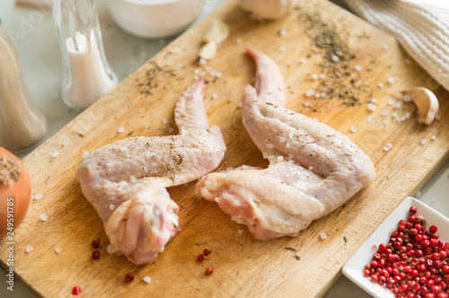 raw chicken wings on cutting Board, spices, salt, raw meat,
