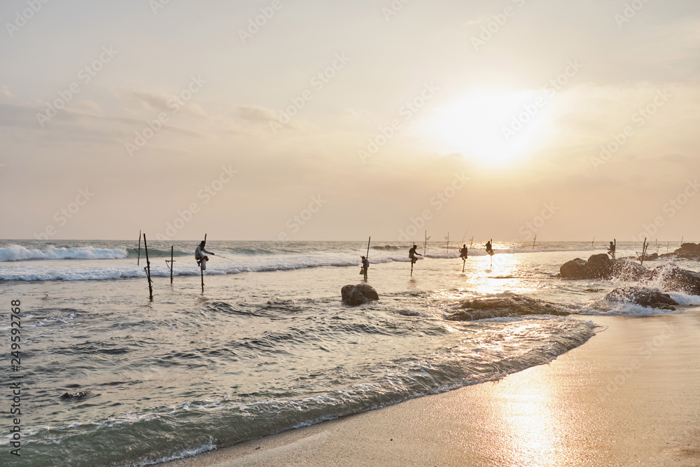 Fishermen of Sri Lanka are fishing at sunset.