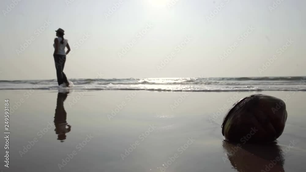 woman is walking on sandbank near ocean, waves are washing coast, calm relaxing shot woman is walking on sandbank near ocean, waves are washing coast, calm relaxing shot