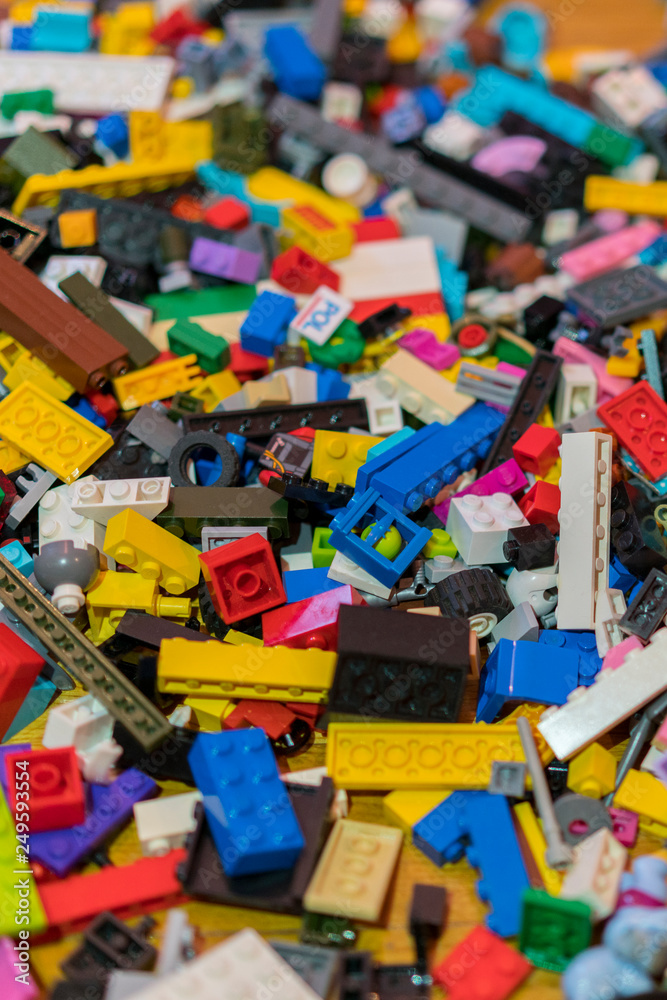 Close up of colorful plastic bricks on the floor. Early learning. Children's plastic constructor on the floor. background. vertical photo
