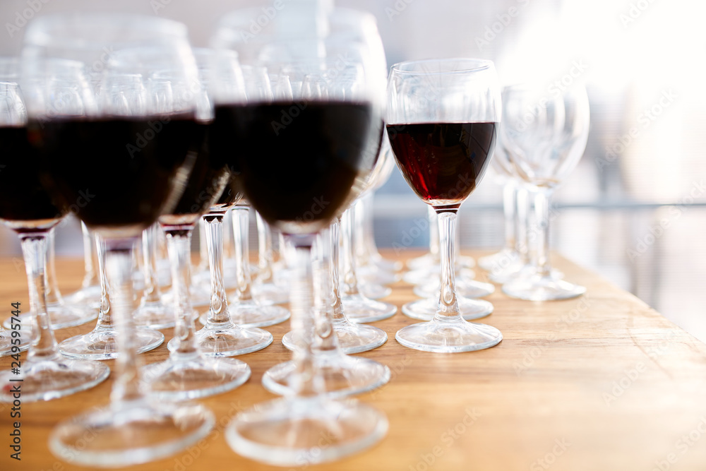 Many glasses with red wine and empty wine glasses 
