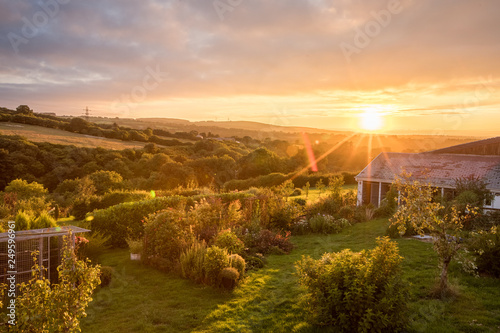 Setting sun casting rays over a large garden in Carmarthenshire photo