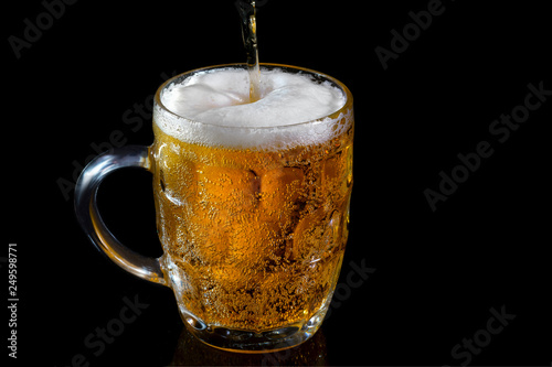 Light beer in a glass on a black background