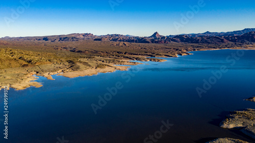 Aerial, drone view of Alamo Lake, Arizona in the remote desert near Wenden with vivid blue water and sky with Alamo Dam © joel