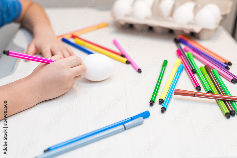 A child will paint Easter eggs with felt-tip pens. Easter ideas. Space for text. Egg tray. Happy easter. A child will paint Easter eggs with felt-tip pens. Easter ideas. Space for text. Egg tray. Happy easter.