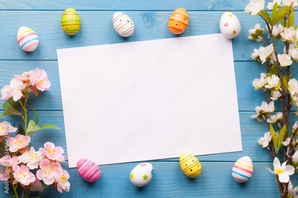 Fototapeta Frohe Ostern Hintergrund mit bunten Ostereiern und einem weißen Zettel