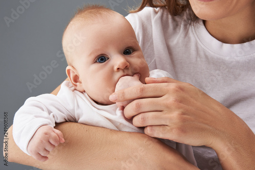 Photo of charming toddler cuddle on mum hands 