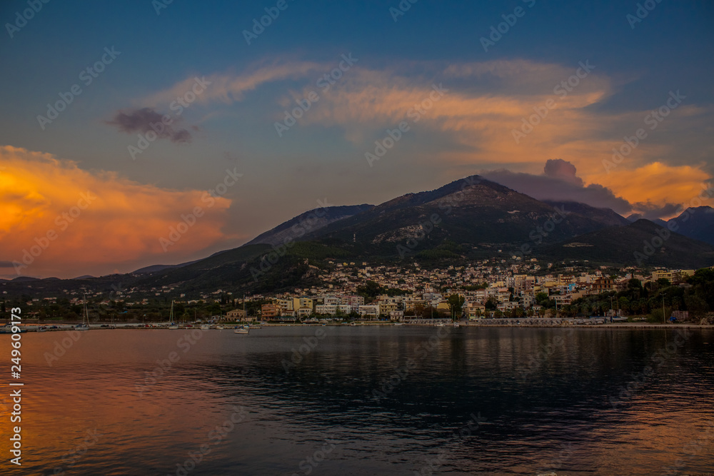 South Europe landscape soft focus view of small city near sea on lonely mountain background in evening twilight time after sunset 