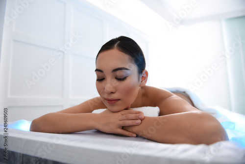 Relaxed asian lady laying on massage table