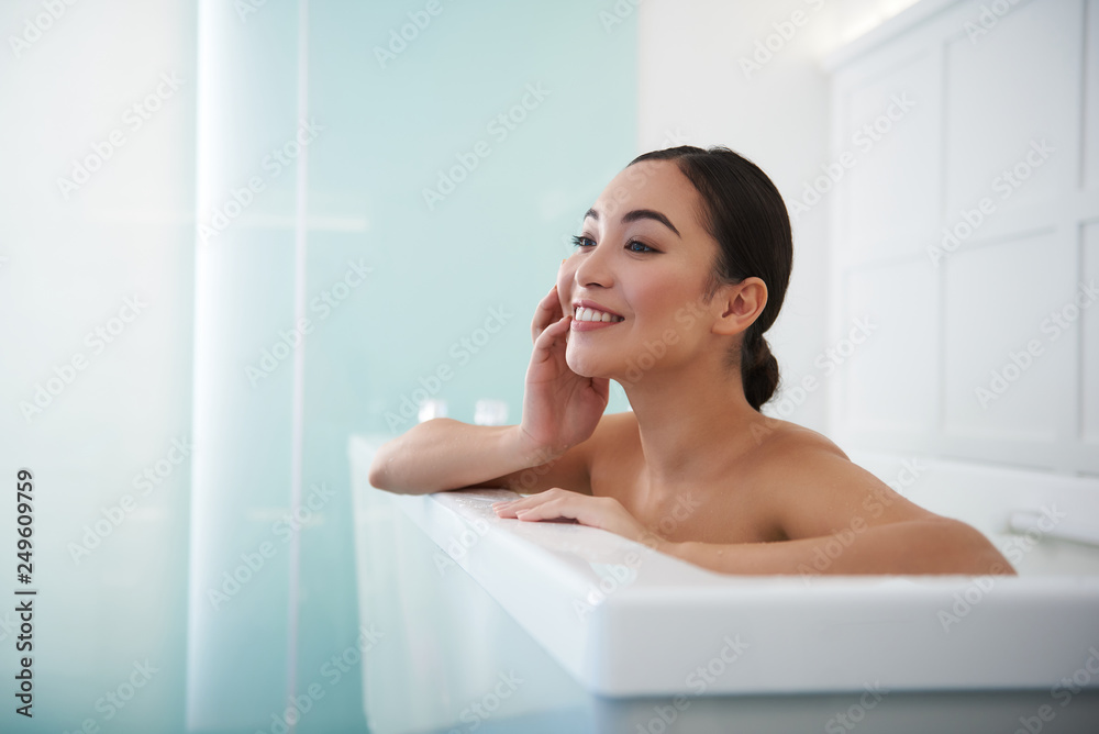 Smiling asian lady enjoying relaxed spa bath Smiling asian lady enjoying relaxed spa bath